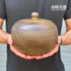 良時美器鶯歌職人純手工手拉坏一斤茶甕，甕身滿布粗獷洗鍊的立體手工跳刀紋理，器形飽滿圓潤，由手掌托起展現三十年永隆瓷藝精湛工藝。